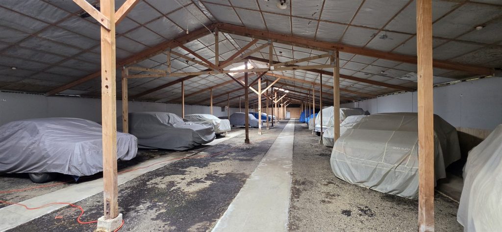 Rows of covered cars stored inside the hall
