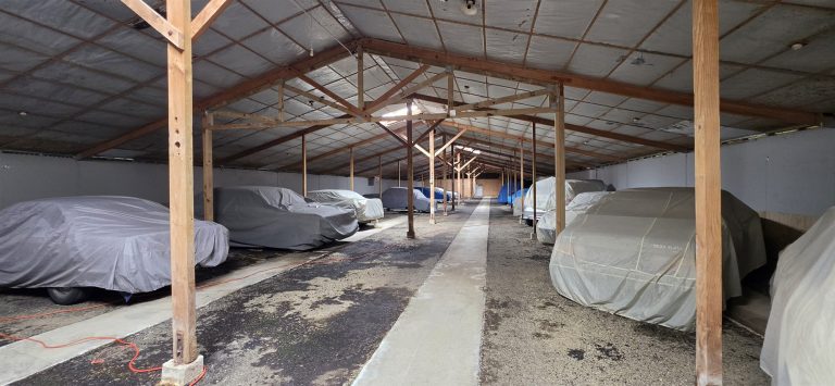 Rows of covered cars stored inside the hall
