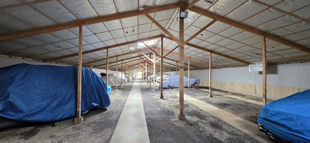 Inside the indoor car storage hall in Johnsonville, with covered cars either side of a long central walkway